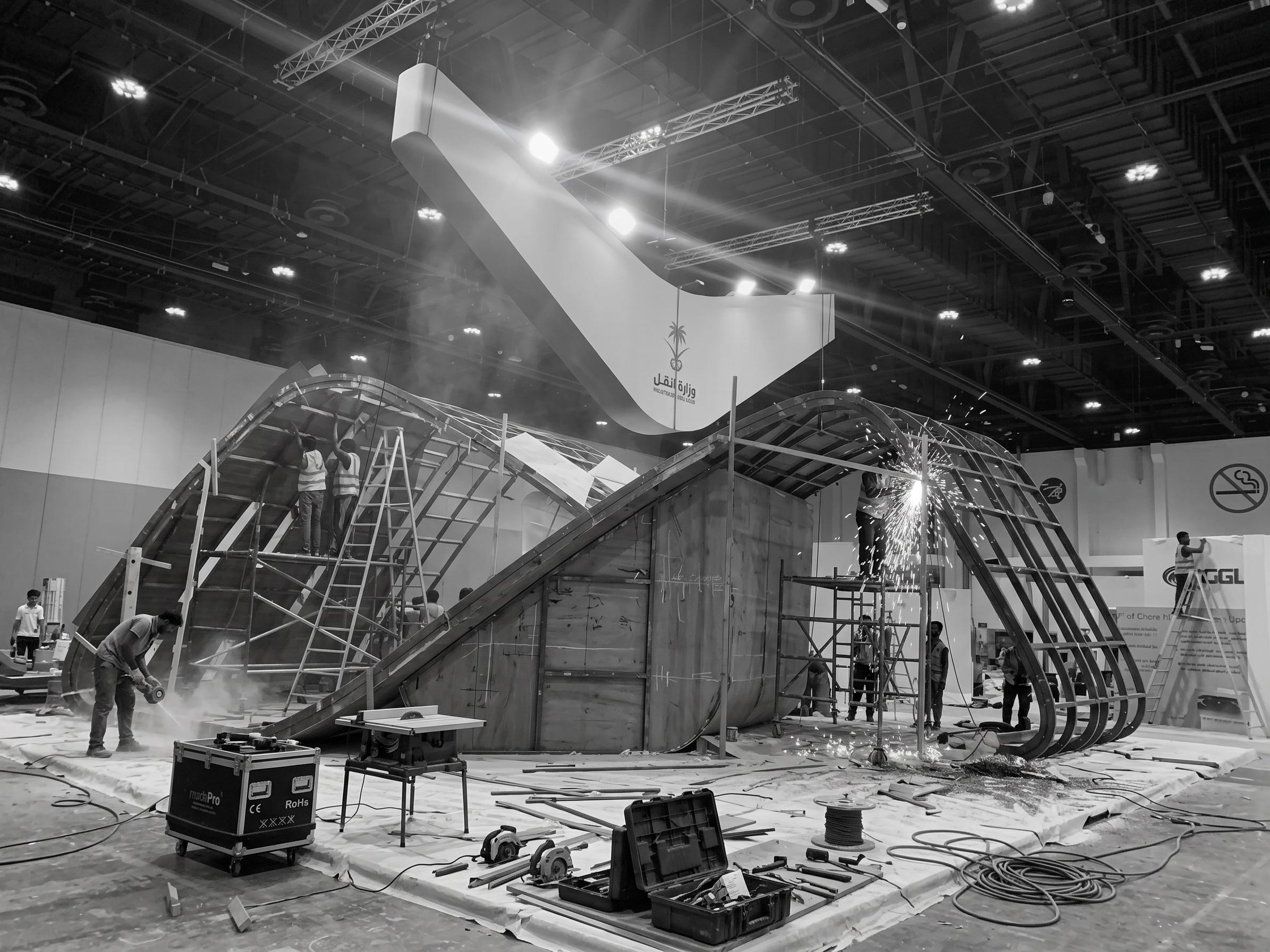 A custom curved structure being built in an exhibition hall